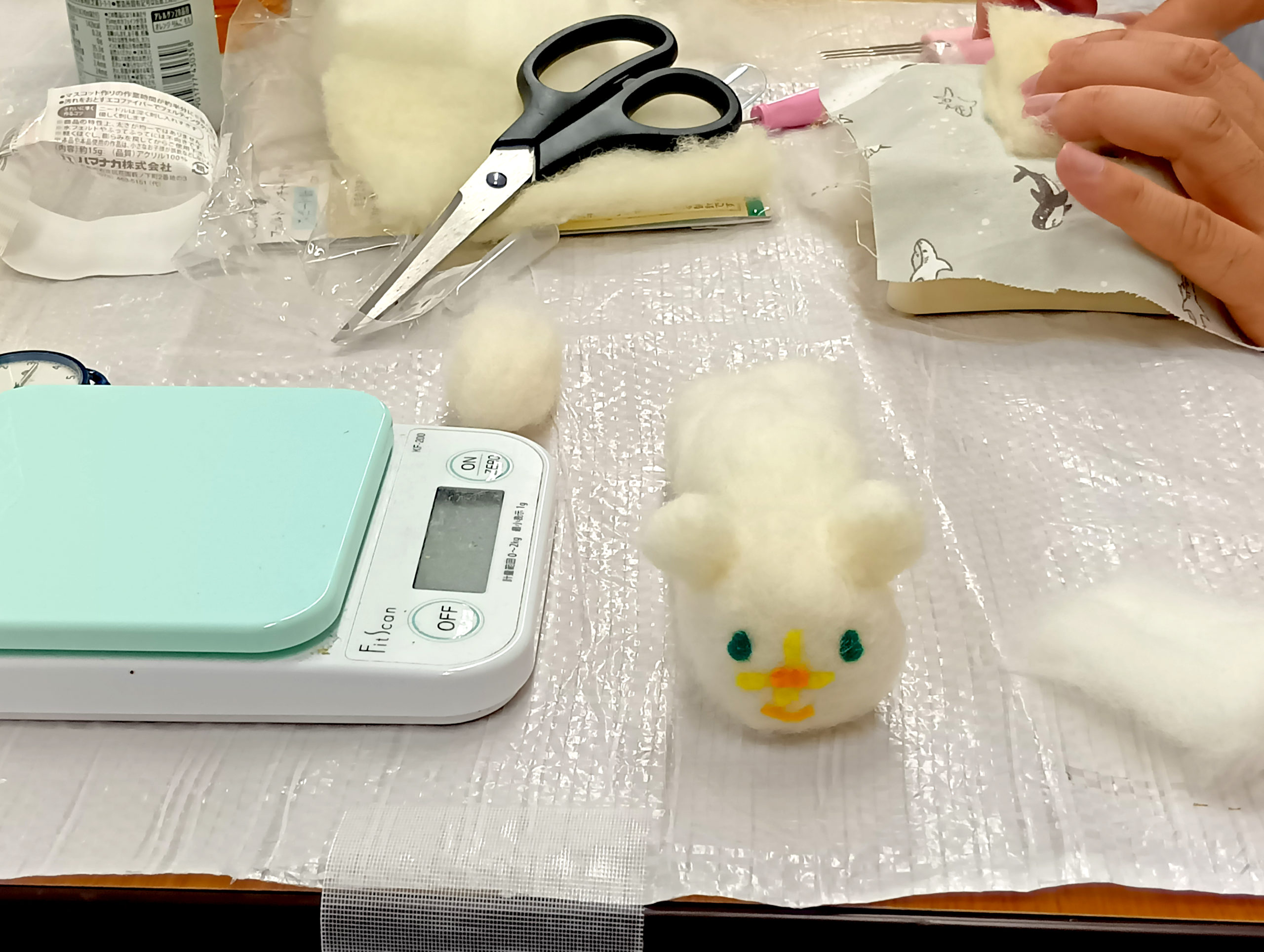 体は白、緑の目、鼻が黄色いお花のフェルトでつくられたシロクマ