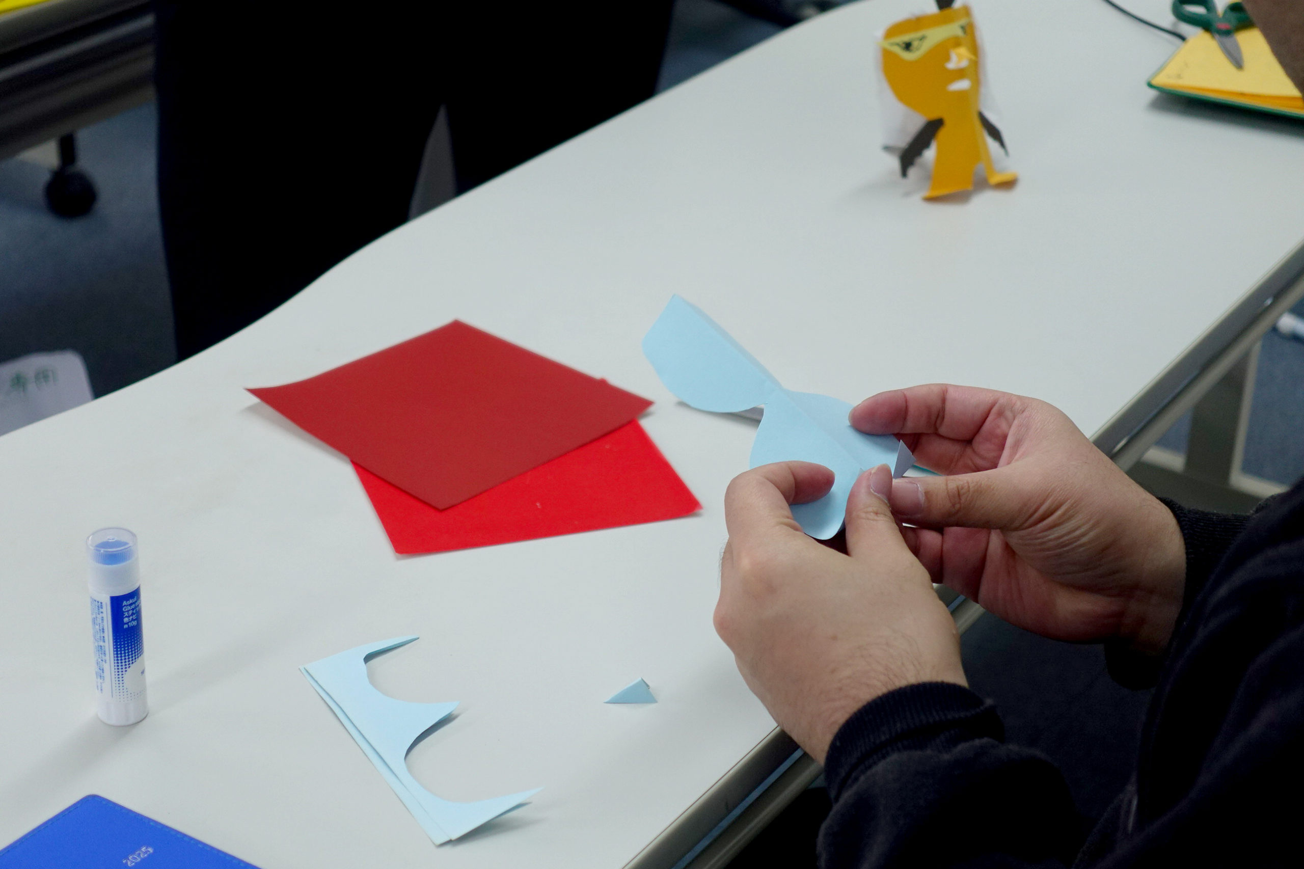 水色の画用紙を丸く雪だるまのかたちにくりぬいている