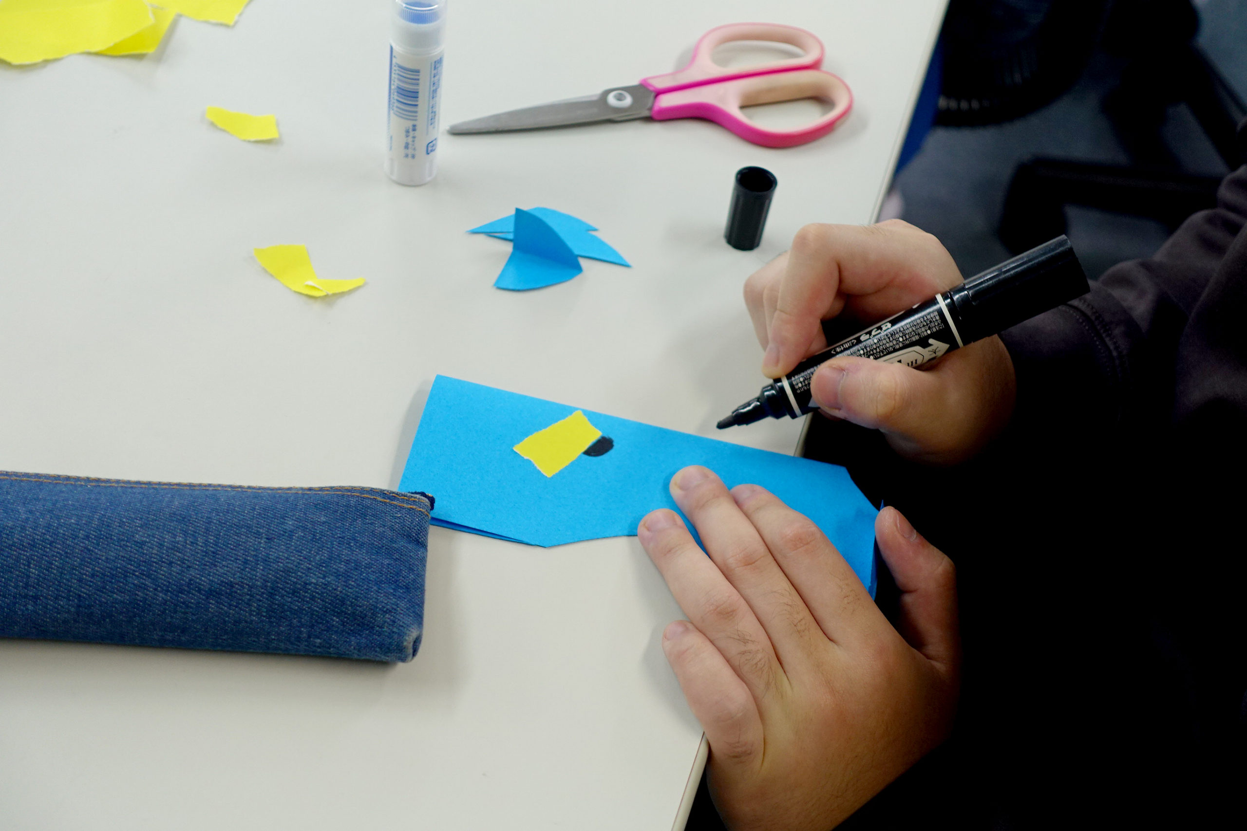 青い画用紙を本体に、手でちぎった黄色い画用紙のパーツをつけたり、マッキーで目を描いたりしてキャラクターを表現